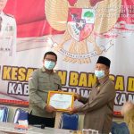 Ketua KPUD Way Kanan Refki Dharmawan SH. menyerahkan piagam penghargaan kepada FKUB